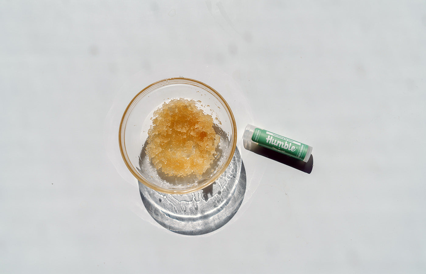 lip scrub and lip balm on a white background
