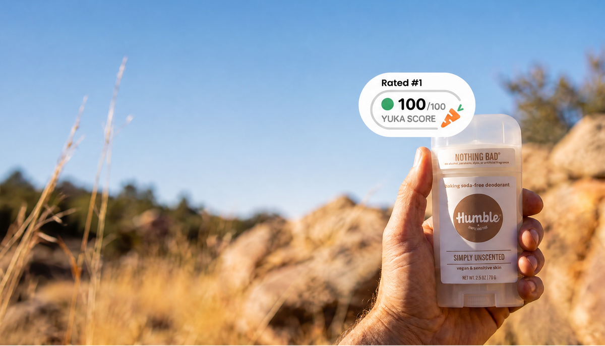 Hand holds Humble Simply Unscented baking soda free deodorant outdoors with a 100 out of 100 Yuka Score badge