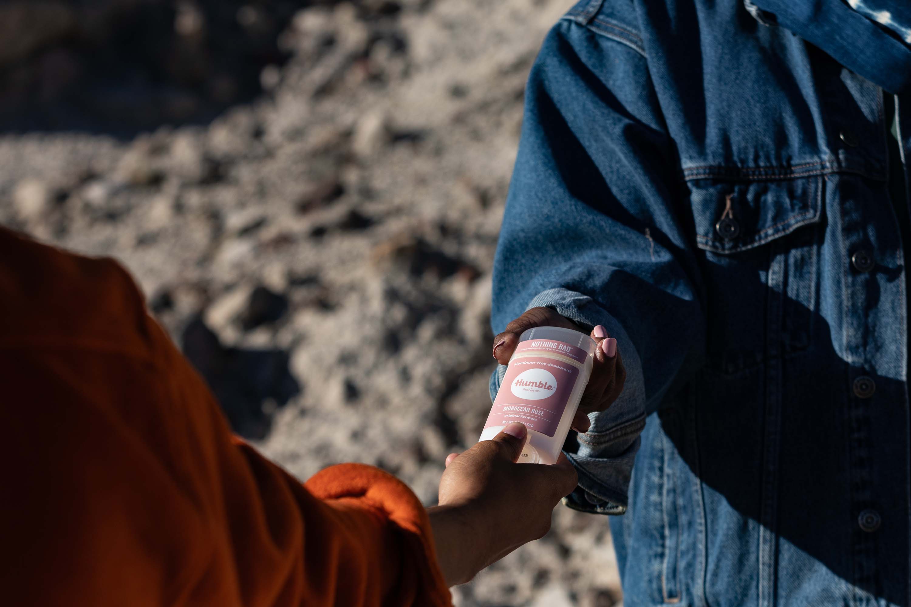 Man passing Moroccan Rose deodorant to woman