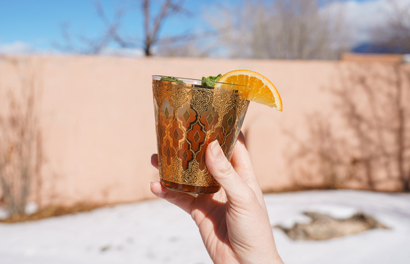 A hand holding a glass of Holy Basil Functional Mocktail