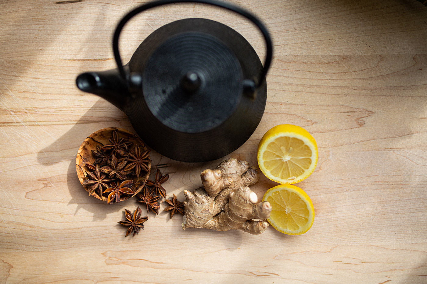 Overhead shot of tea ingredients and pot on wooden table