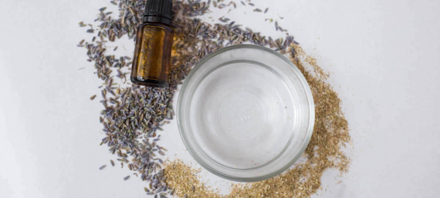 Bowl of water with chamomile and lavender buds spread around a white table