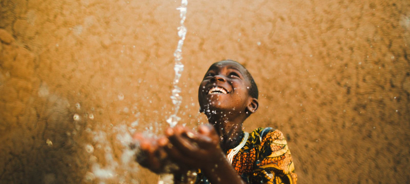 Water pouring into smiling child's hands