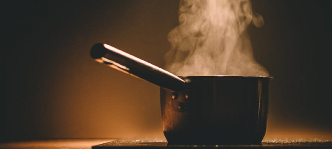 Steam coming off a pot of water on the stove