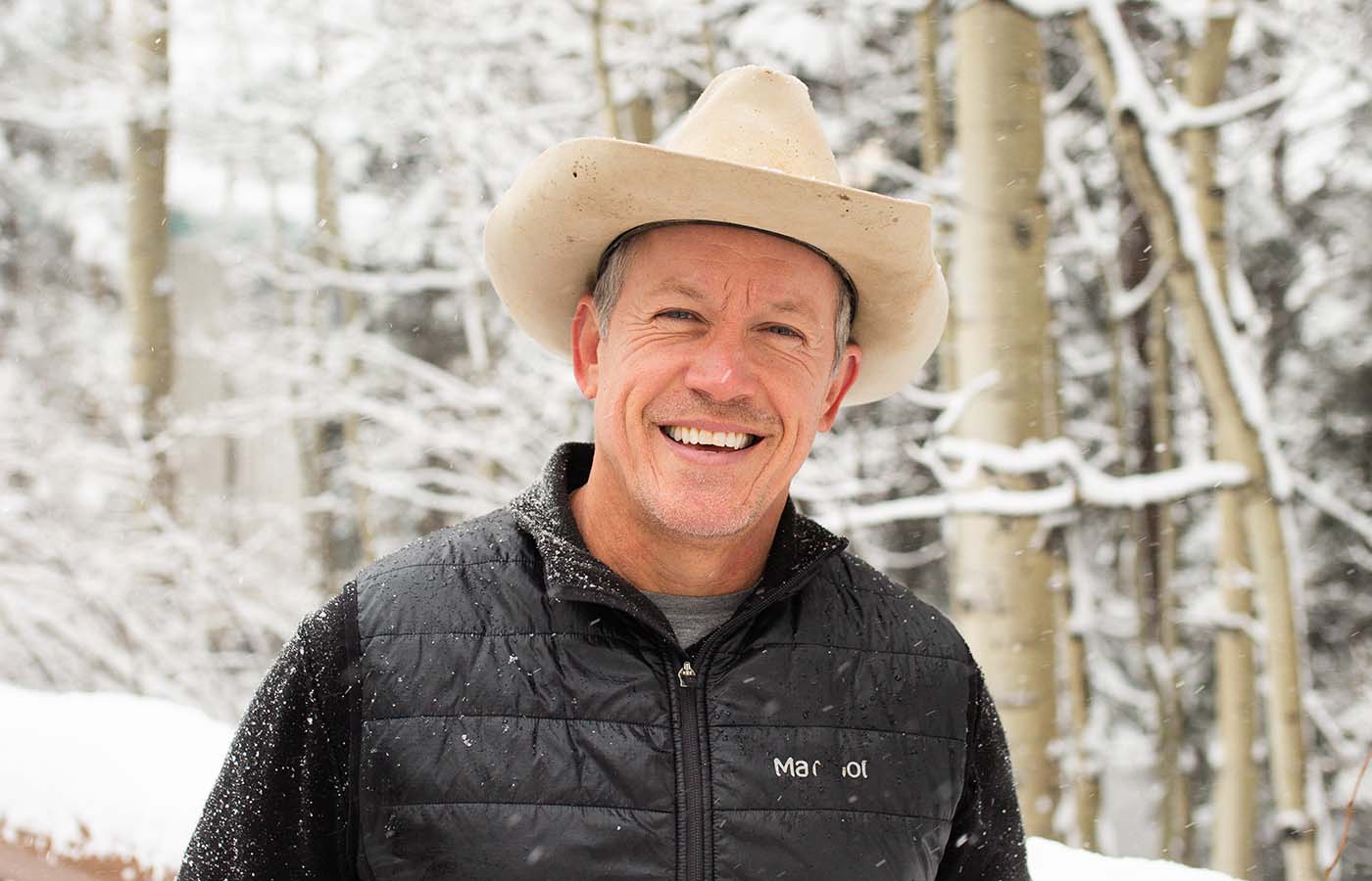 Man in hat with snowy backdrop