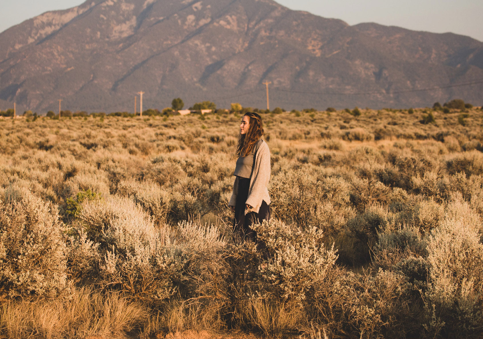 Woman standing in mountainous desert surrounded by wild sage plants