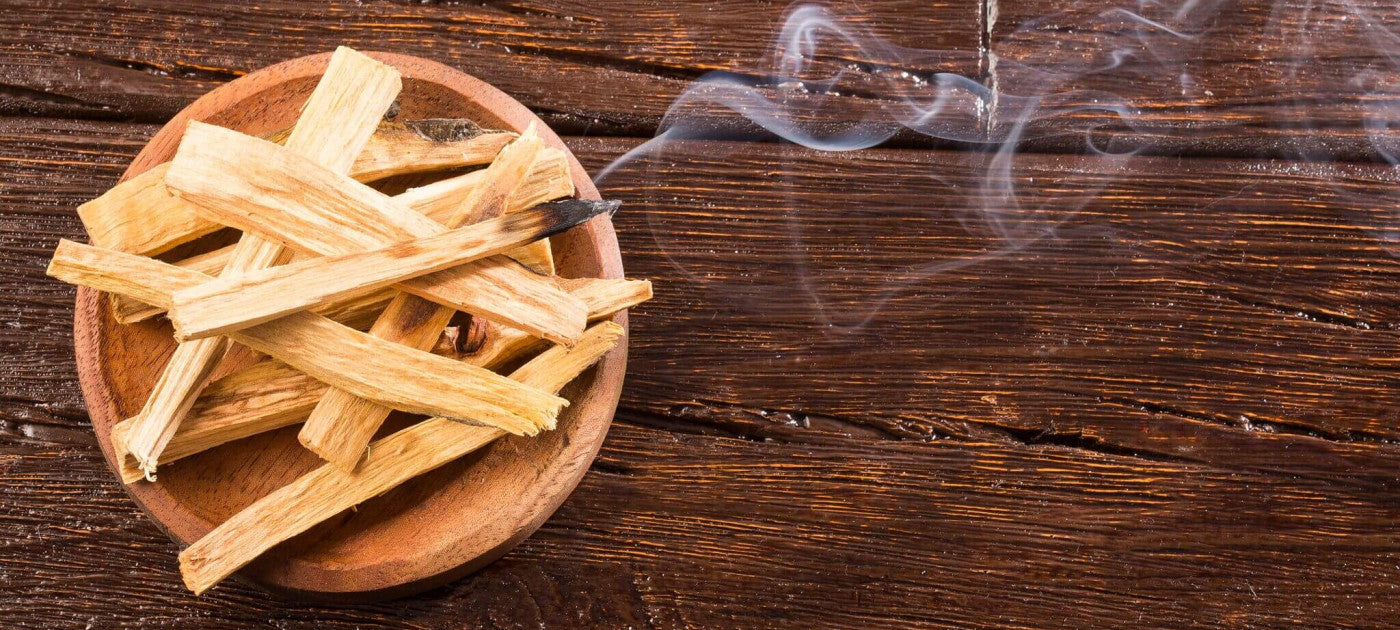 Bowl of palo santo with one smoking sticks