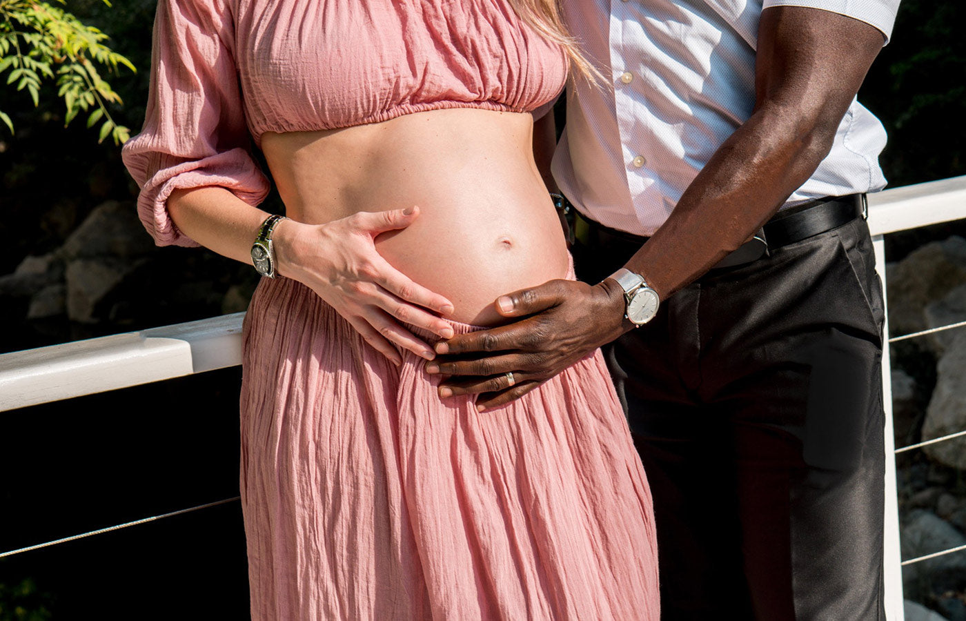 Woman and partner with hands on her pregnant belly