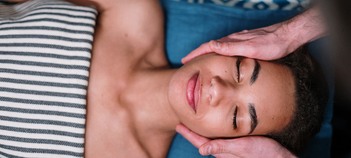 Overhead shot of peaceful woman receiving a facial massage