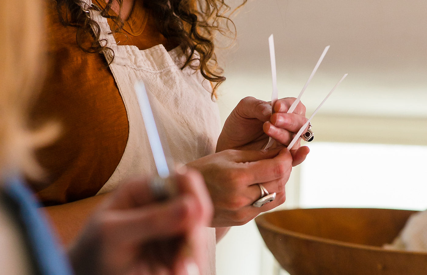 Close up of two women's hands holding paper scent strips