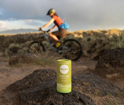 Person riding mountain bike outdoors with deodorant stick in foreground
