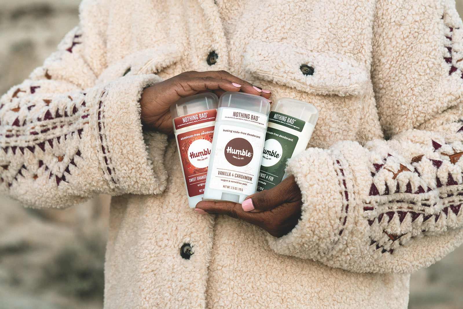 Woman holding three deodorants