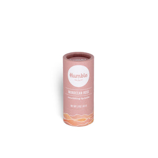Front view of Humble Moroccan Rose lip balm in pink paperboard tube with label and mountain illustration on white background