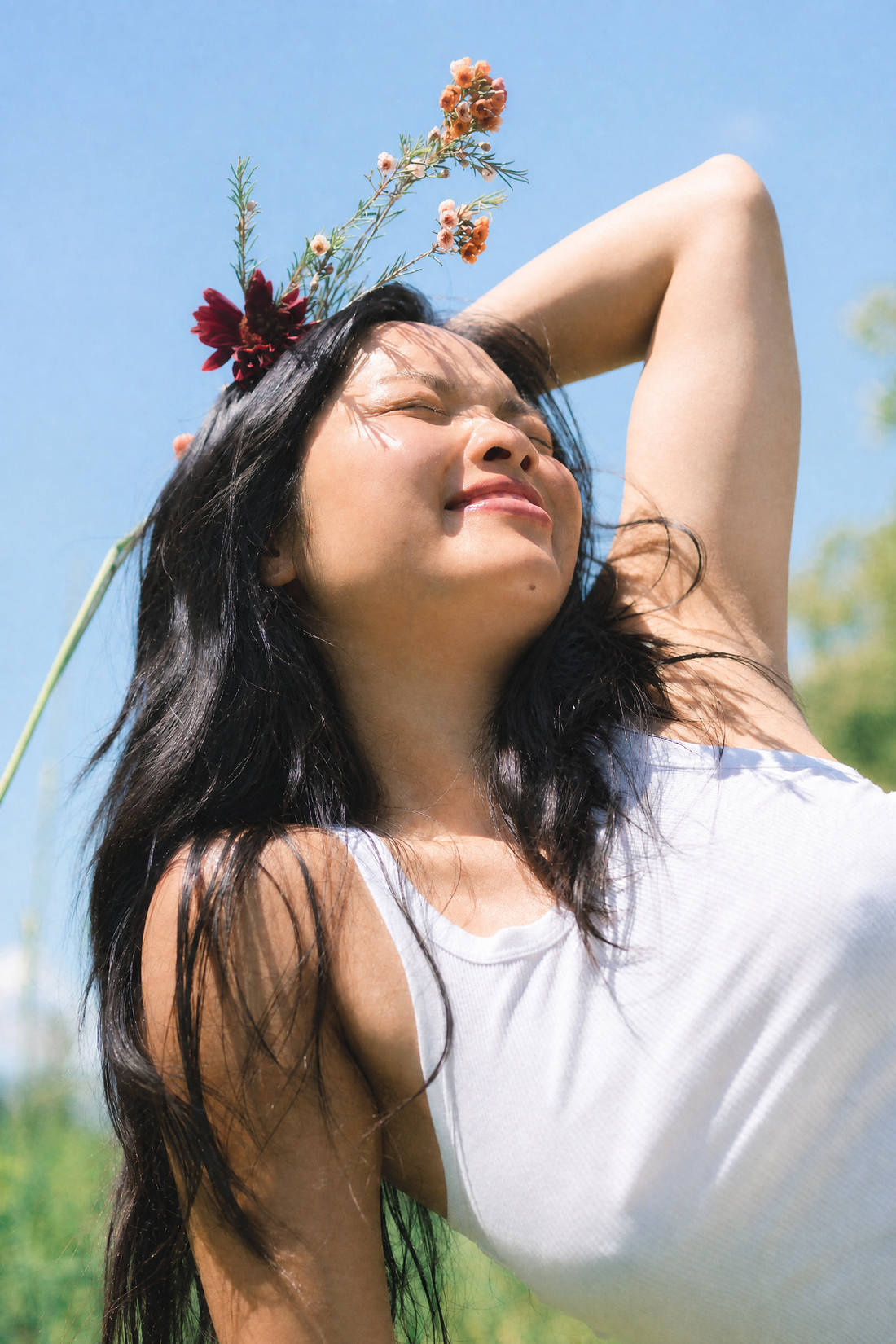 Woman with flowers in her hair against a blue sky