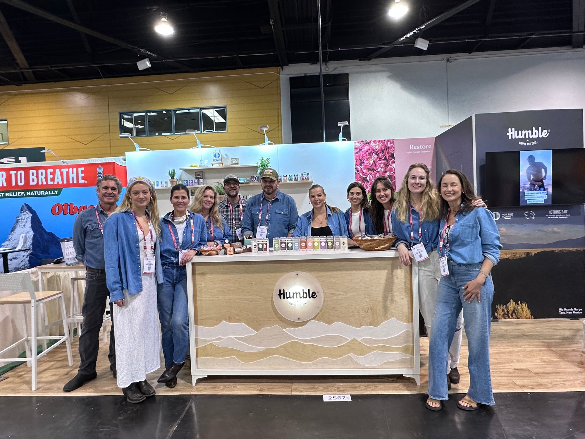 Group of people posing in front of a booth with 'Humble' branding at an event.