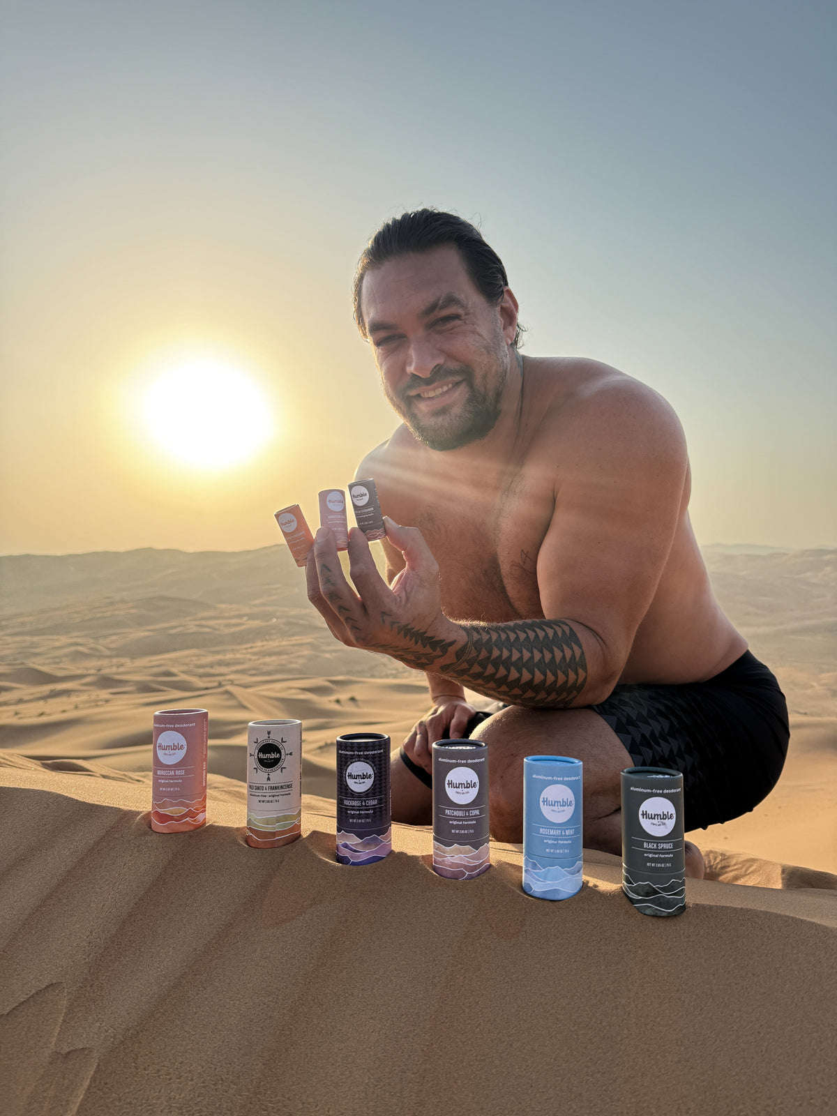 Man in the desert with skincare products on sand