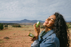 woman in jean jacket smelling deodorant in the desert 