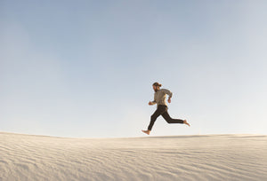a man runs through a sandy desert 