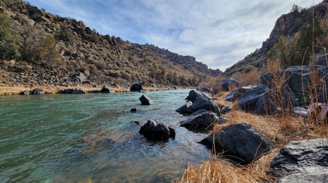 River flowing through a rocky landscape with mountains in the background
