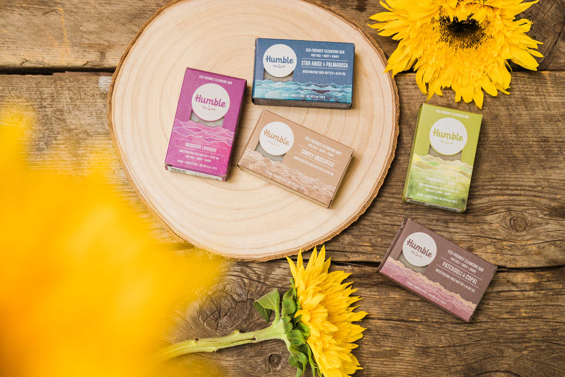 soap boxes arranged on a wooden background with yellow flowers