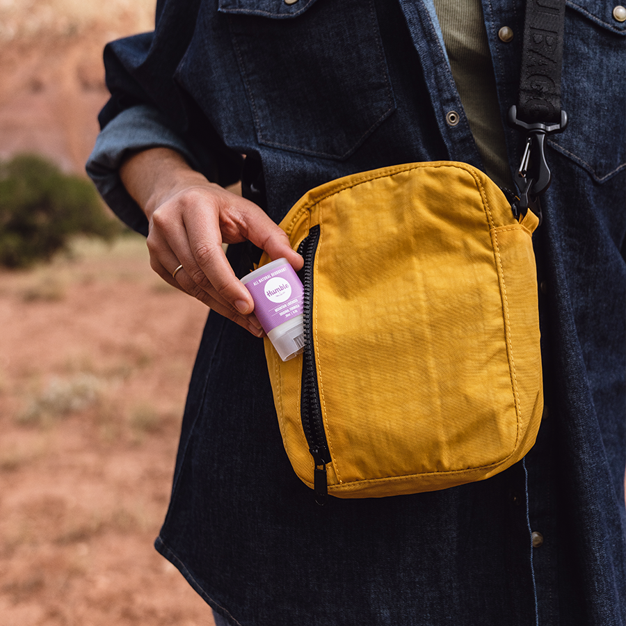 a travel sized deodorant being put into a yellow bag 