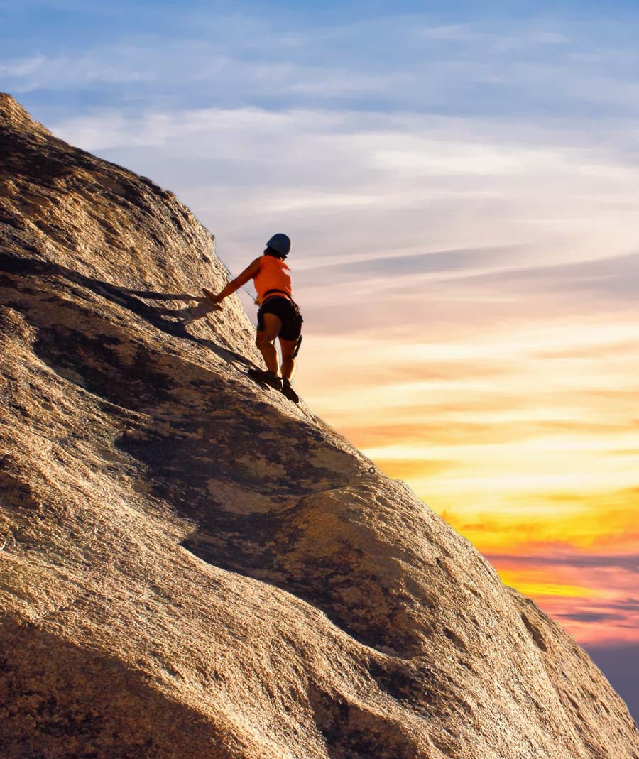 a person rock climbing at sunset 